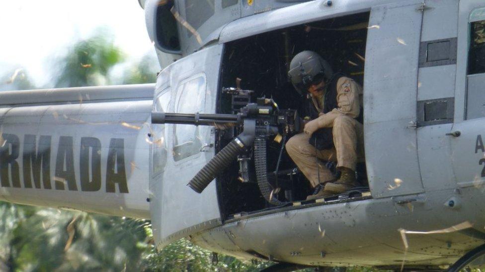 A soldier looks out a helicopter gunship on patrol in Putumayo province in the Colombian Amazon