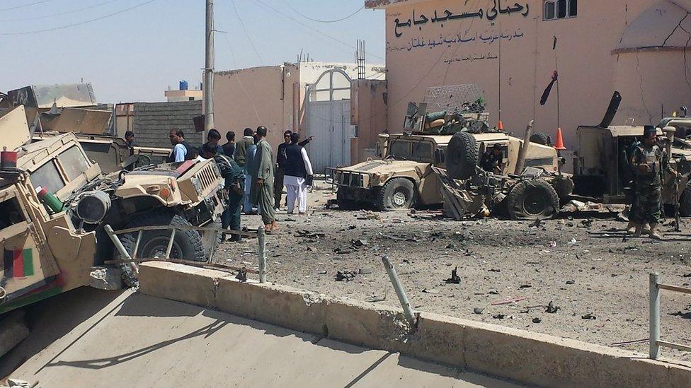 Afghan security personnel inspect the site of a suicide attack near the main police headquarters in Lashkar Gah, capital of Helmand province, 23 August 2017