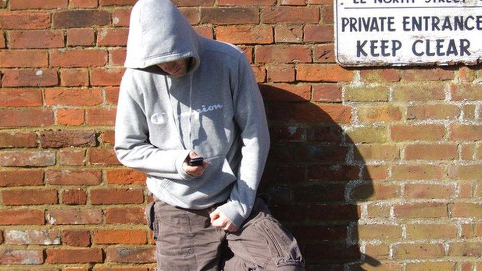 Man in a hoody using a mobile phone