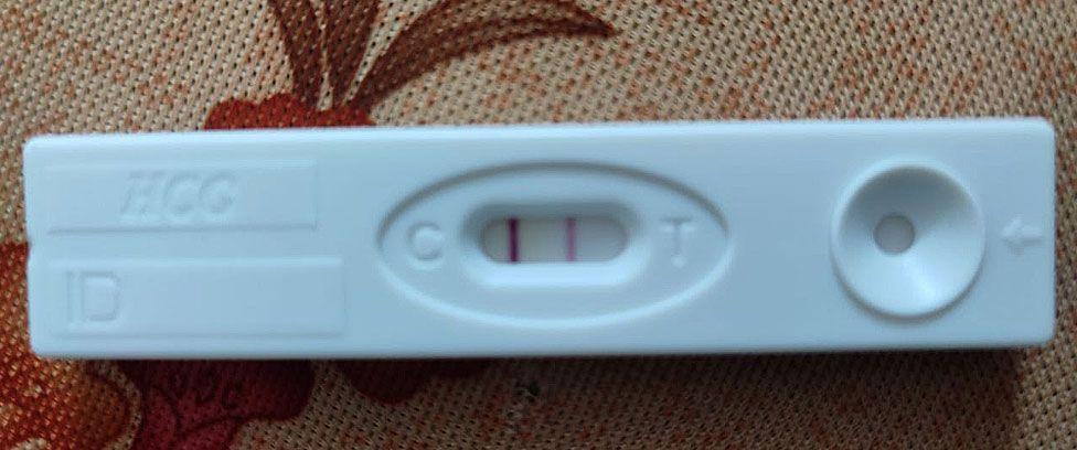 A white plastic pregnancy test showing two lines, indicating a positive result.