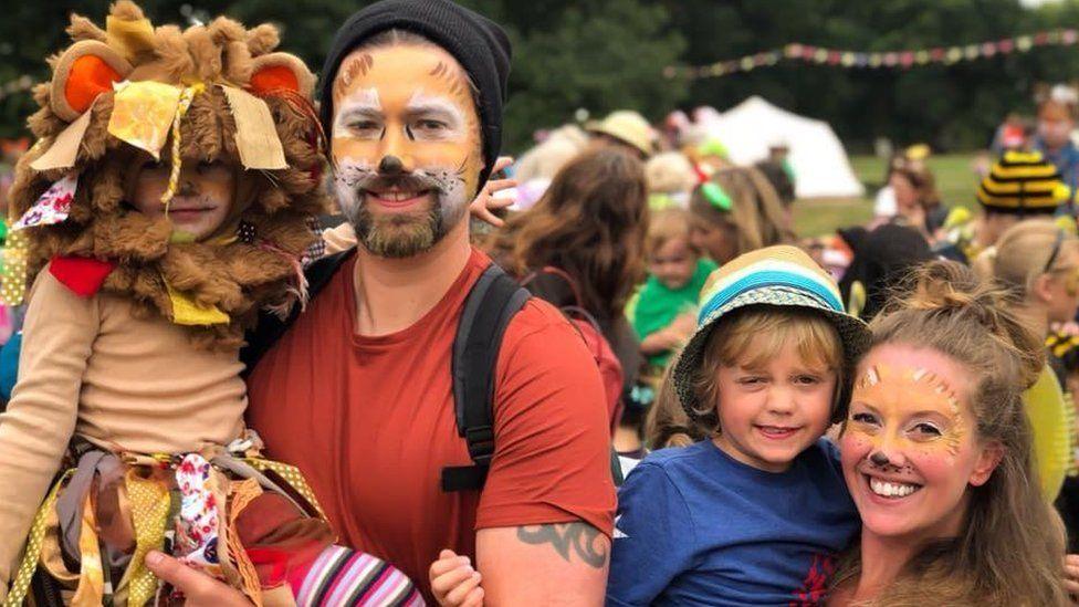 Kelly with her husband Michael and their children Sam and Isla all smiling and with their faces painted at a fare