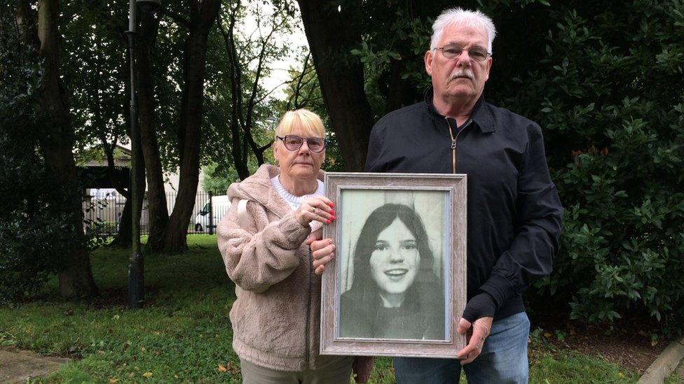 The photo shows May and Martin McGavigan holding a photo of their later sister, Annette.