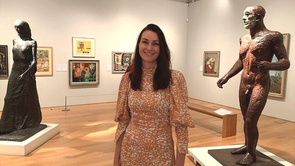 Jo Baring standing between two sculptures