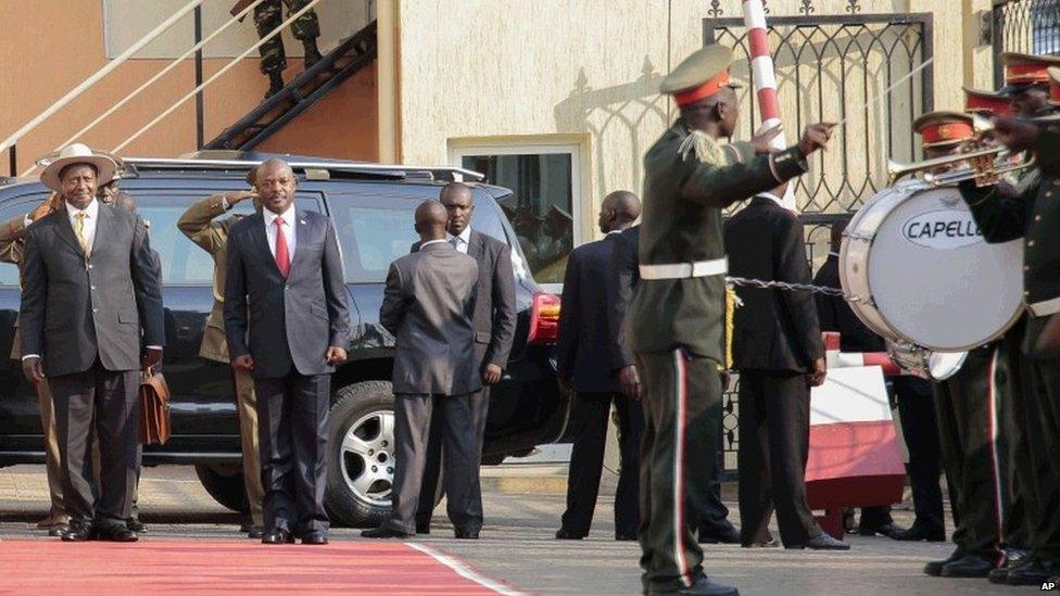 President of Uganda Yoweri Museveni, left, is welcomed by the President of Burundi, Pierre Nkurunzira, right, in Bujumbura, Burundi, Tuesday, July 14, 2015.