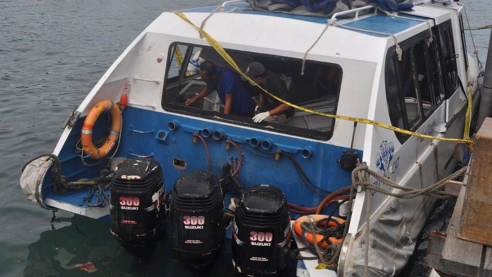 Police investigators examine the Gili Cat 2 boat following an explosion off Bali, Indonesia, on 15 September