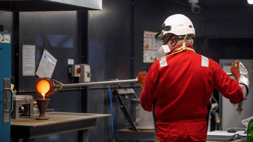 Worker pouring heated gold