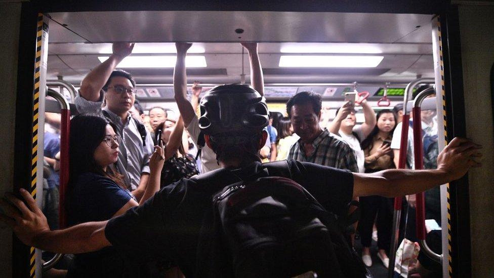 A protester blocks the MTR underground train from closing