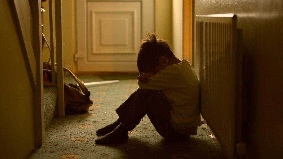 Generic image of sad child sat on floor