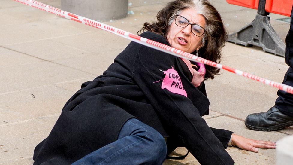 Protester with hands glued to the pavement