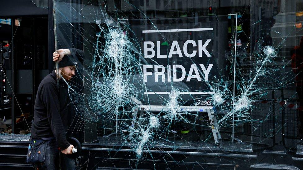 A glazier remove a broken pane of glass from a shopfront in Dublin city centre