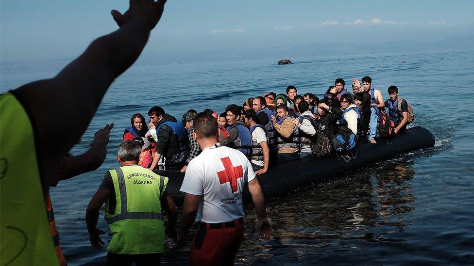 A group of migrants land on a beach on the Greek island of Lesbos after crossing from Turkey (19 October 2015)