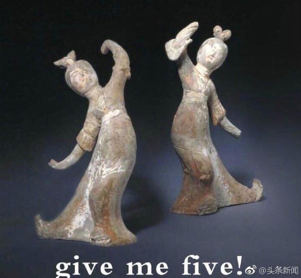 High-fiving Chinese figurines