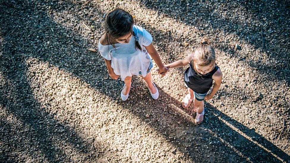 two girls hold hands