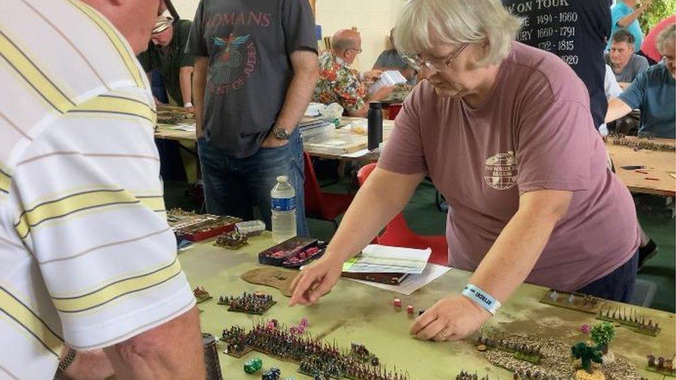 A wargamer shows off their figurines at the event