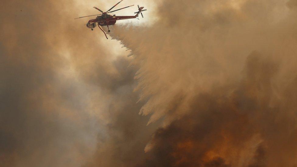 Helicopter dropping water over fire