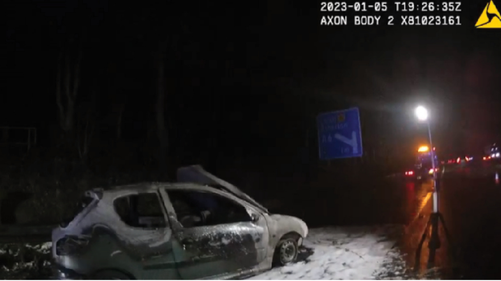 A police handout of the couple's burnt out car on the M61 near Manchester.