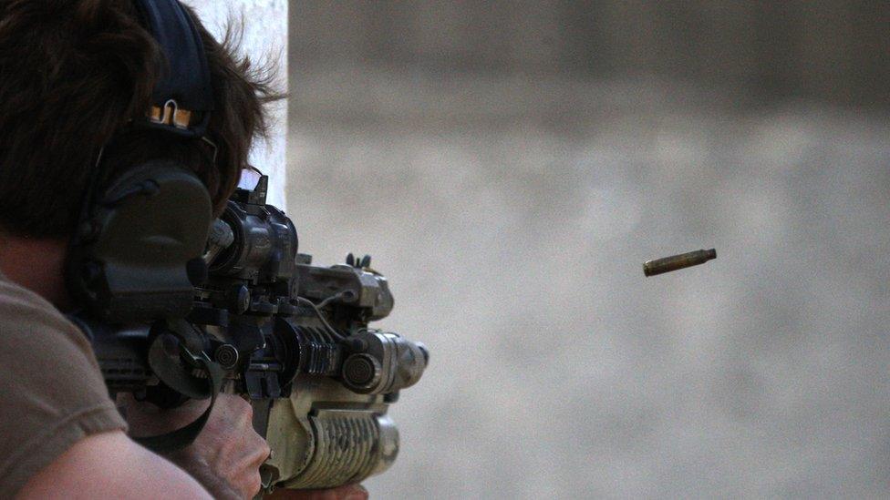 A US Special Forces soldier shoots with an assault rifle on a firing range