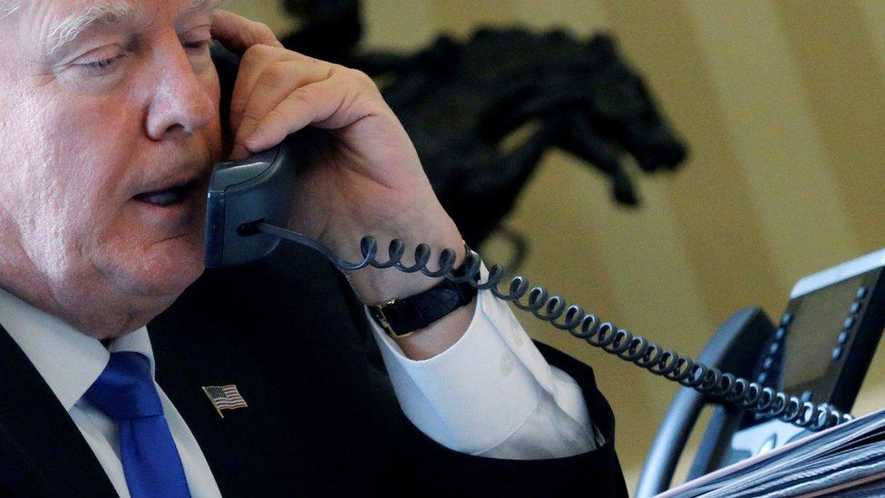 US President Donald Trump speaks by phone in the Oval Office at the White House in Washington, 28 January 2017