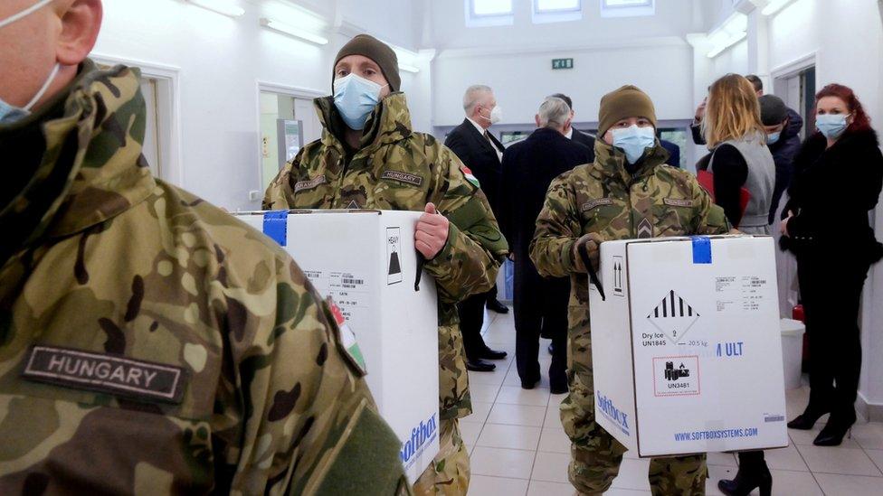 Hungarian soldiers carry the first shipment of Pfizer-BioNTech vaccines