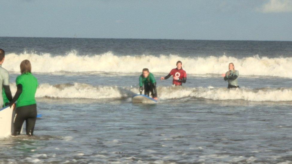 Mentor encouraging student surfing