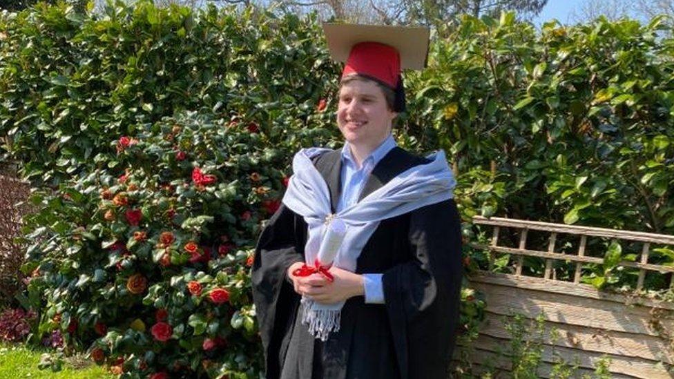 David Harvey in graduation gown and makeshift hat.