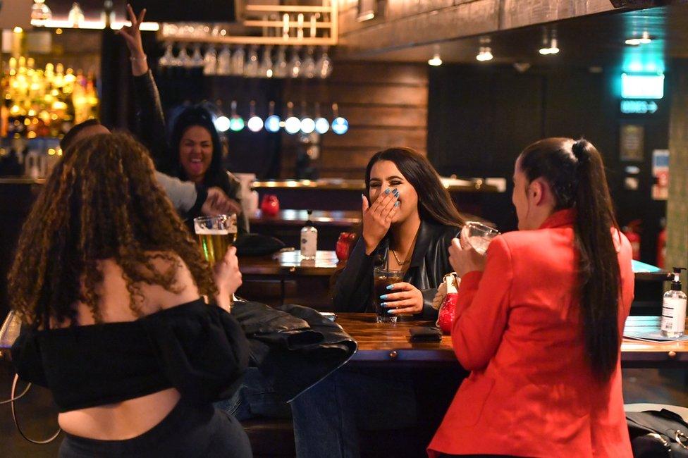 A group of friends drink together in a bar in Manchester on 17 May, following the easing of lockdown restrictions