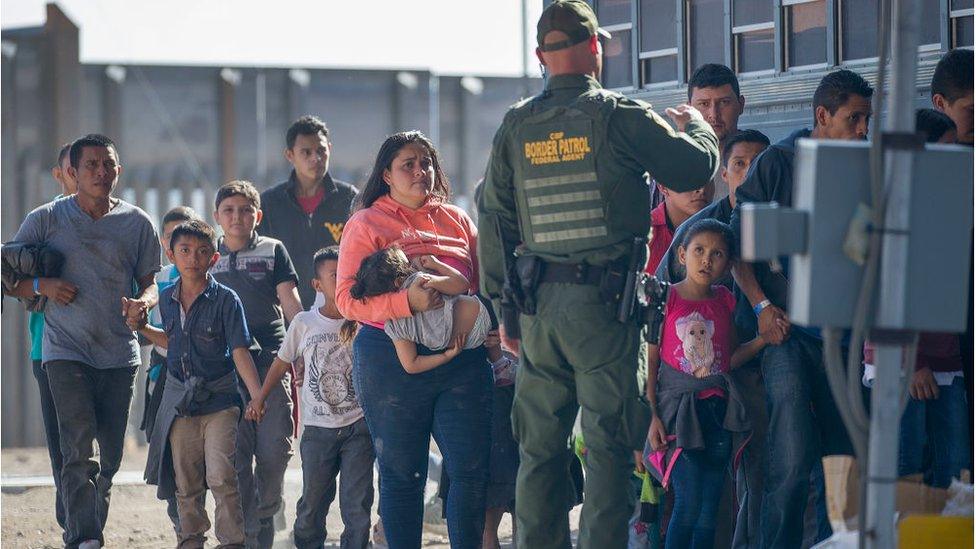 Migrants are loaded onto a bus by U.S. Border Patrol agents after being detained when they crossed into the United States from Mexico