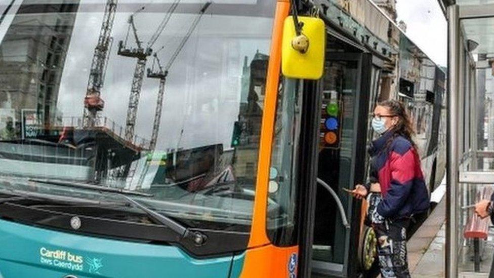 Passengers in masks getting on a bus in Cardiff