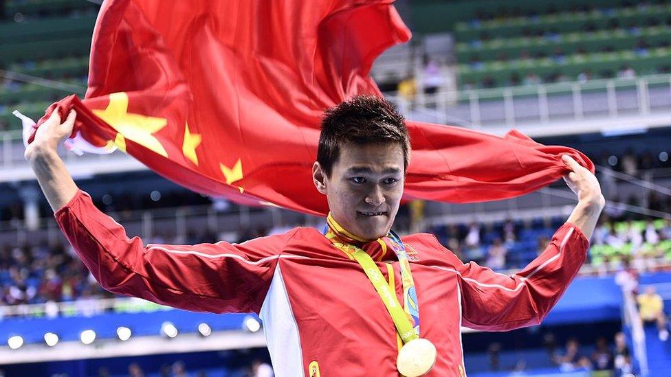 China's Sun Yang waves his national flag on the podium after he won the Men's 200m Freestyle Final during the swimming event at the Rio 2016 Olympic Games