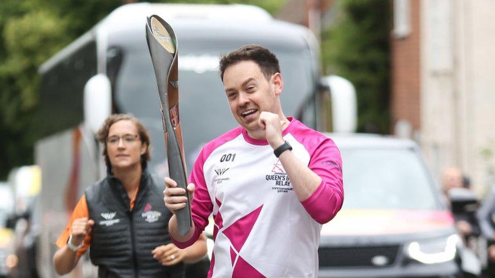 Baton bearer Chris Luck holds the Queen's Baton during the Birmingham 2022 Queen's Baton Relay on a visit to Kenilworth