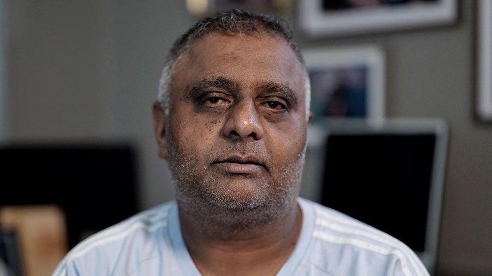 Former sub-postmaster Harjinder Butoy sitting on a chair at his home in Chesterfield