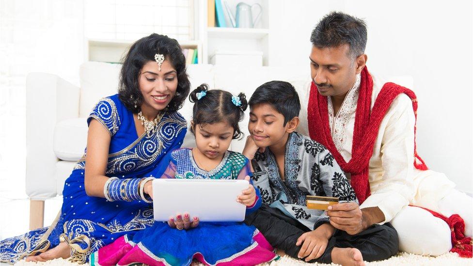 An indian family looking at a computer