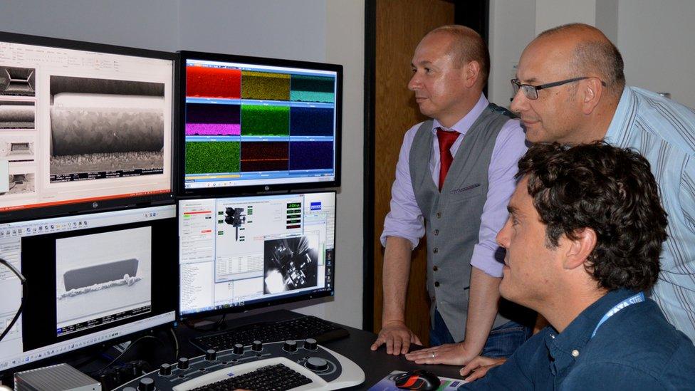 Three scientists looking at some screens