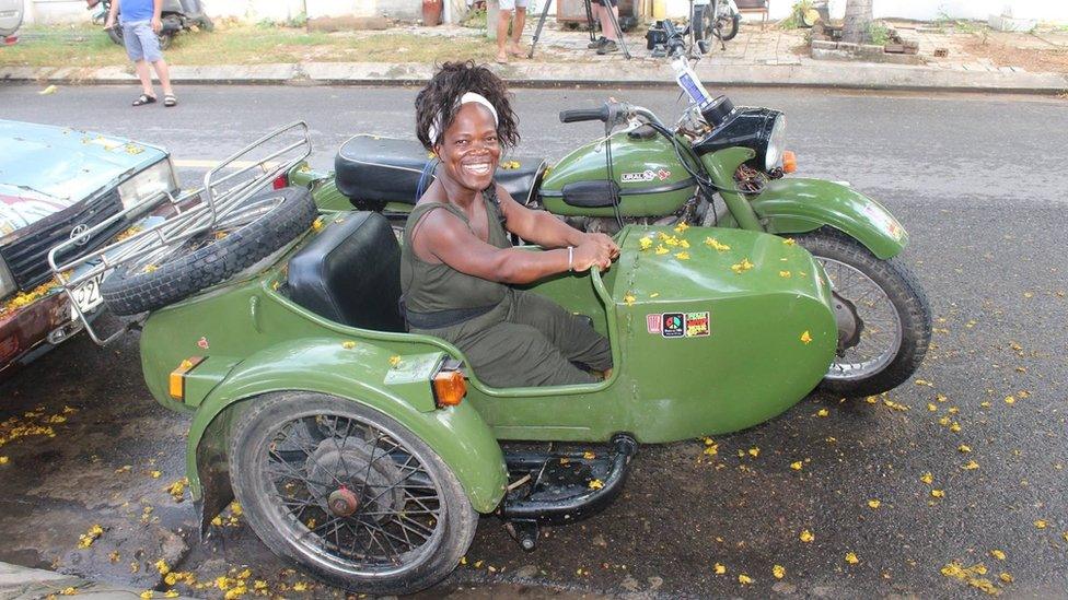 Mary Russell sitting in the pillion seat of a Vietnam motorbike