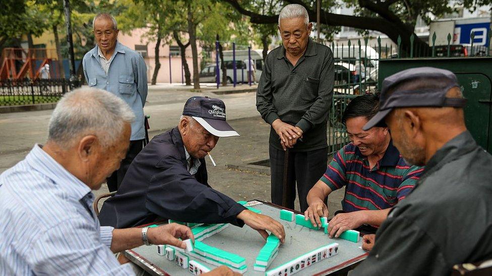 Men play mah-jong in a street