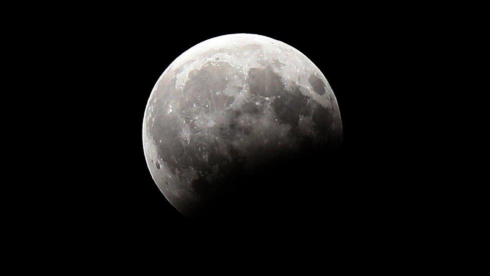 A picture shows the moon during a partial lunar eclipse as seen from Kuwait City on August 7, 2017.