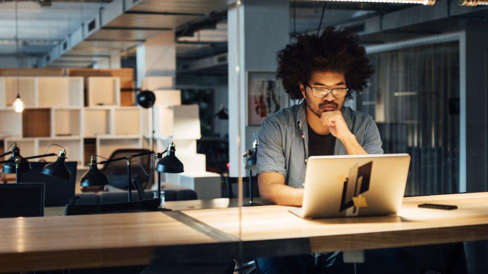 Man sits in front of laptop at night