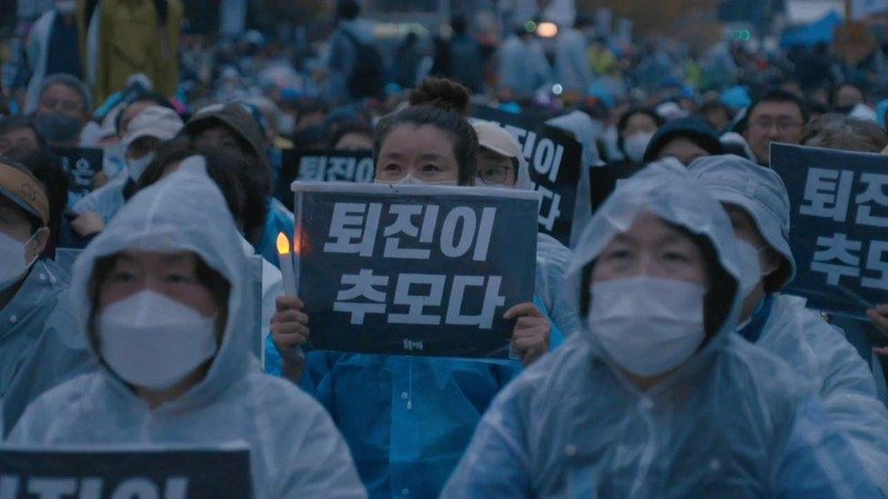 Protesters demand the resignation of President Yoon at a protest on 12 November, holding signs saying "Resignation is remembrance" in Korean