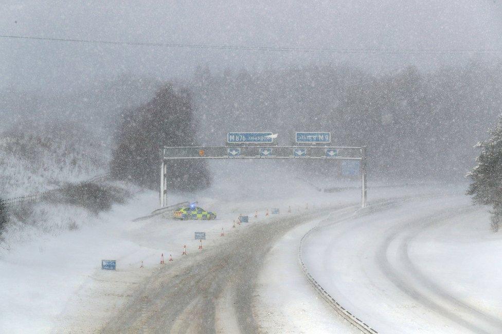 A police car in the snow on the M876 to Glasgow