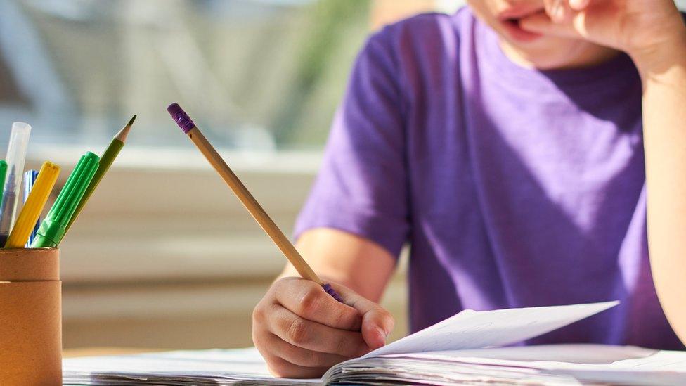 A boy writing in a note book