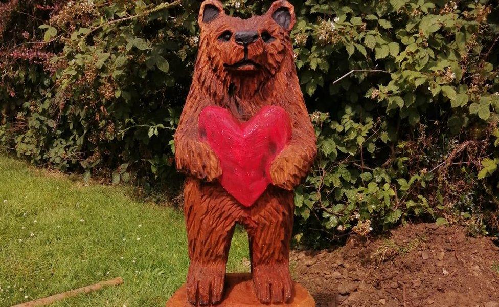 A statue of a bear holding a red heart