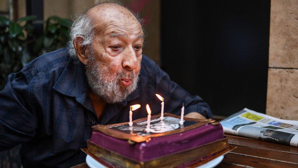 Ara Guler blows candles on his 90th birthday cake on August 16, 2018