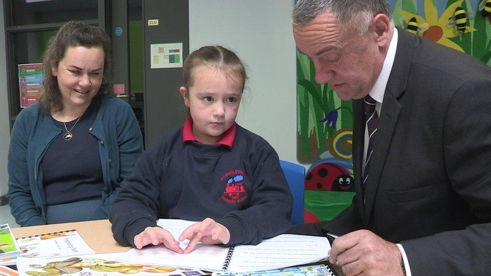 Eryn demonstrates Braille reading to Maghaberry Prison governor David Kennedy