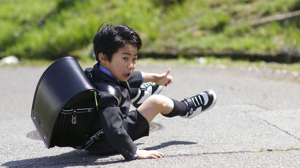 Young boy fell down because weight of his randoseru backpack is too heavy