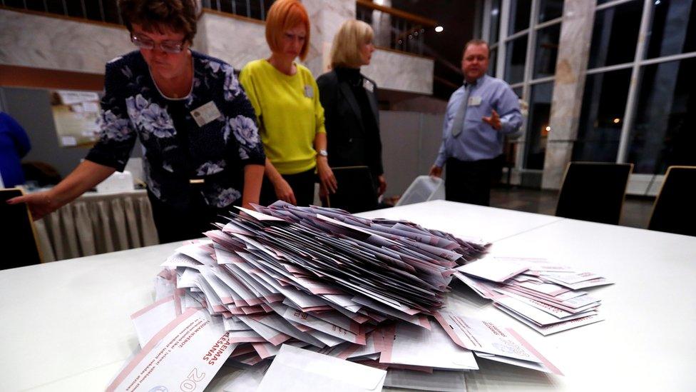 Election officials open ballot boxes during the general election in Riga, Latvia October 6, 2018.