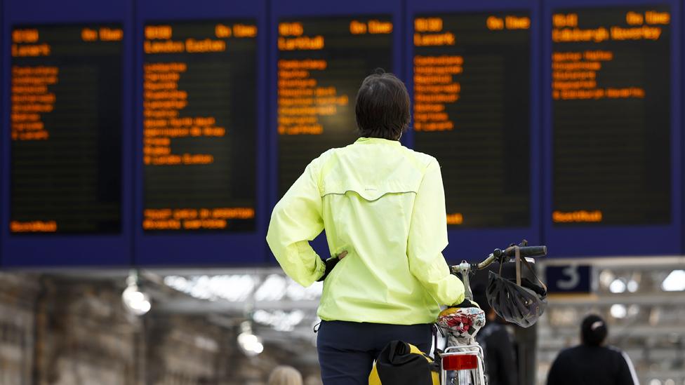 Person looks at the train times at a railway station