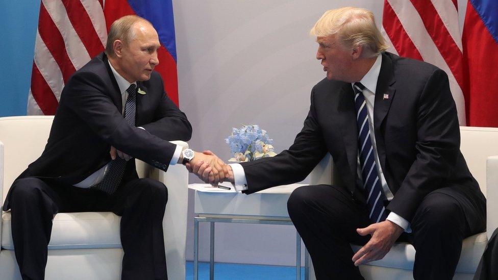 Vladimir Putin and Donald Trump shake hands