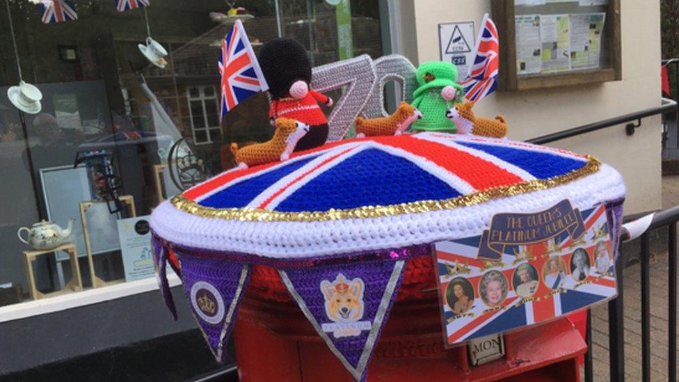 A knitted post box topper showing beefeaters, the queen and a union jack in Groombridge, Kent