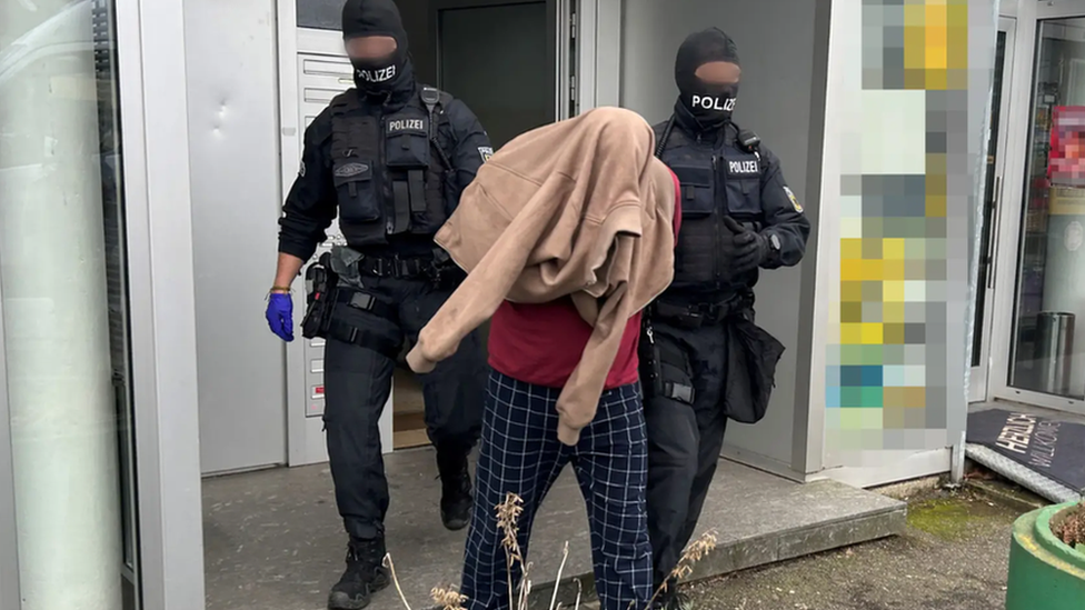 An individual being arrested by two police officers