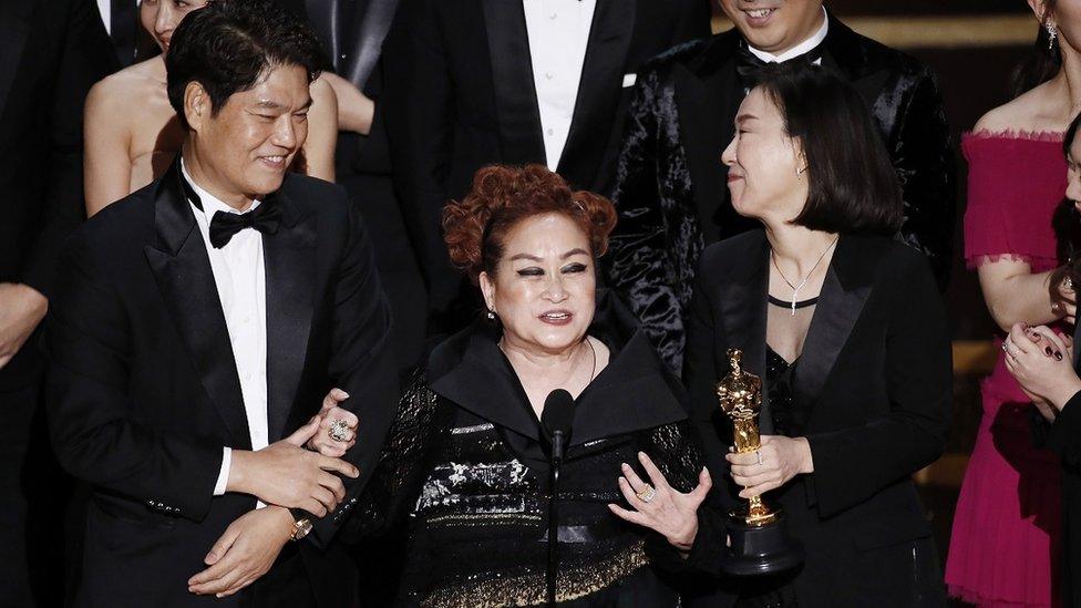 Miky Lee (centre) speaks at the Oscars